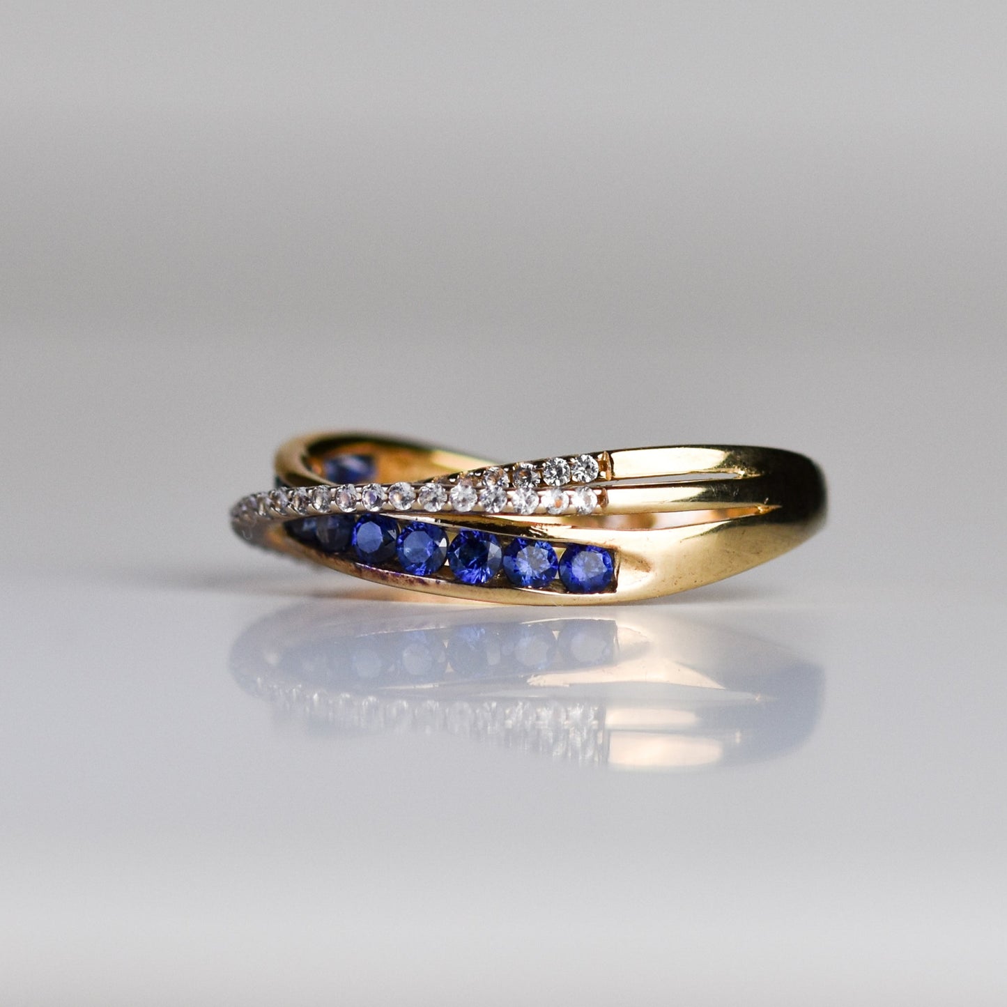 Anillo Cruzado con Zafiros Azules y Blancos en Baño de Oro 14k