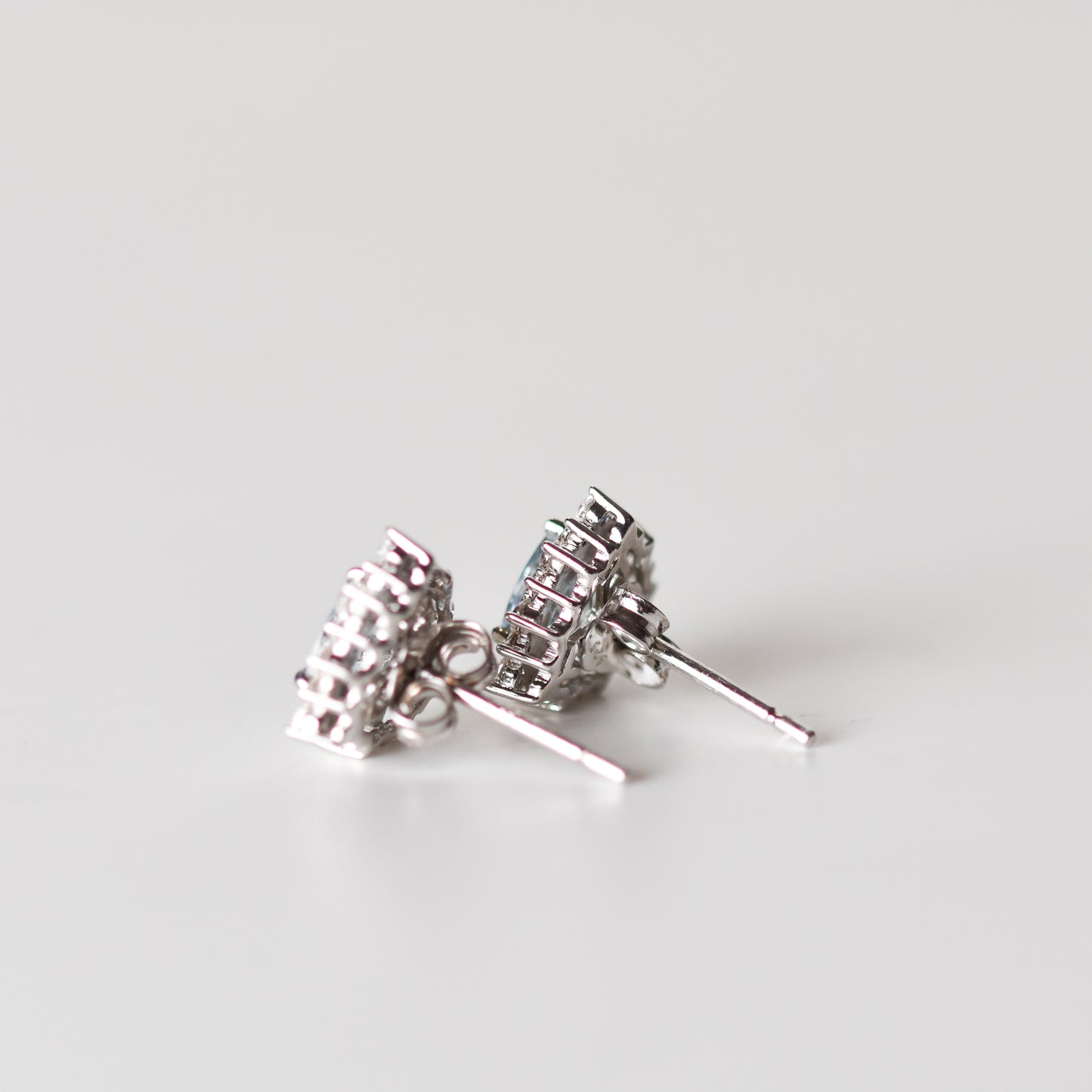 Aretes tipo stud con aguamarina natural y halo de zafiros blancos creados en laboratorio