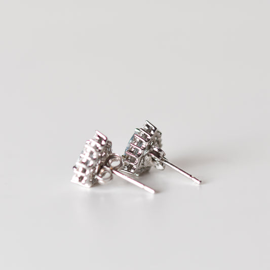 Aretes tipo stud con aguamarina natural y halo de zafiros blancos creados en laboratorio