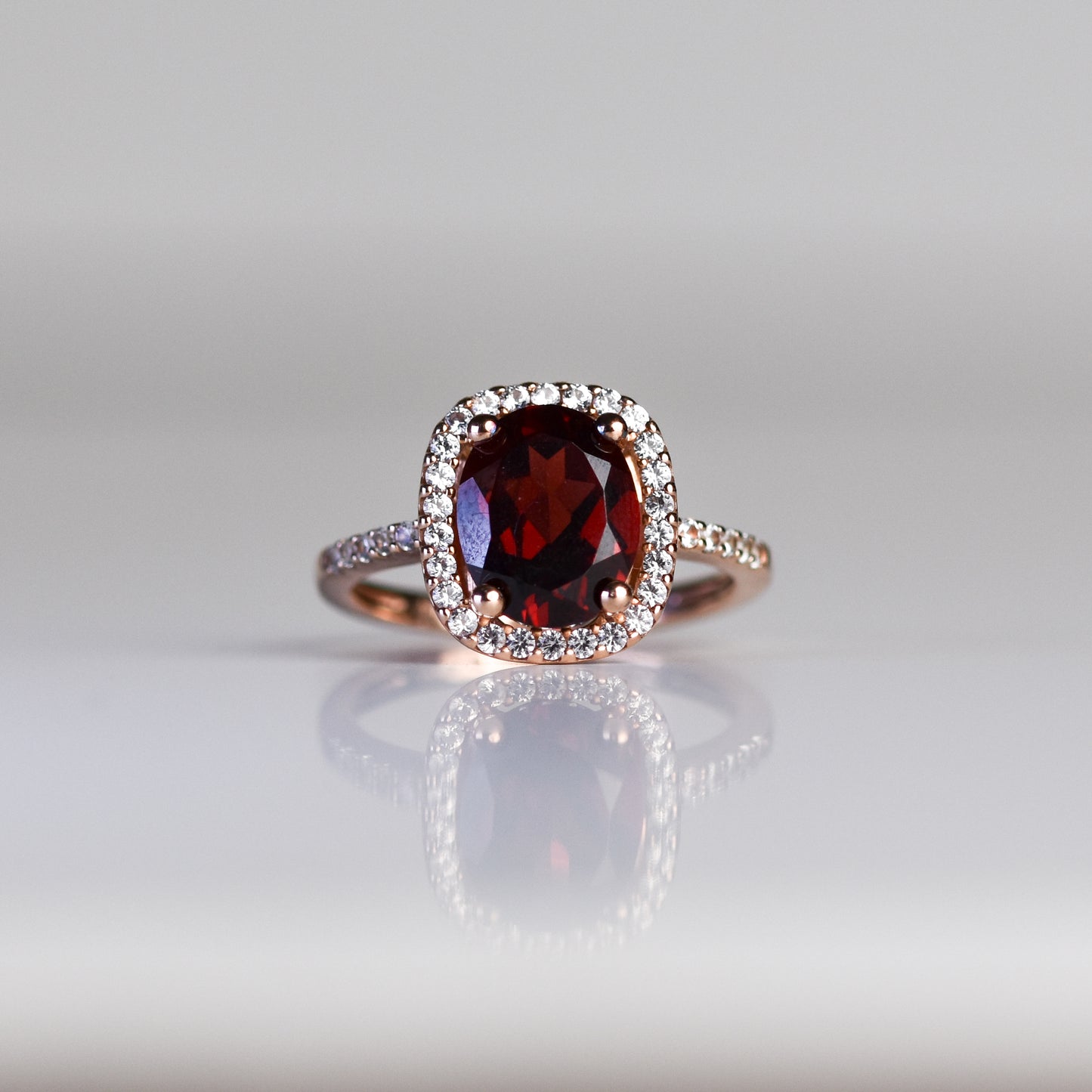 Anillo con granate natural y zafiros blancos en plata esterlina con baño de oro rosa 14K