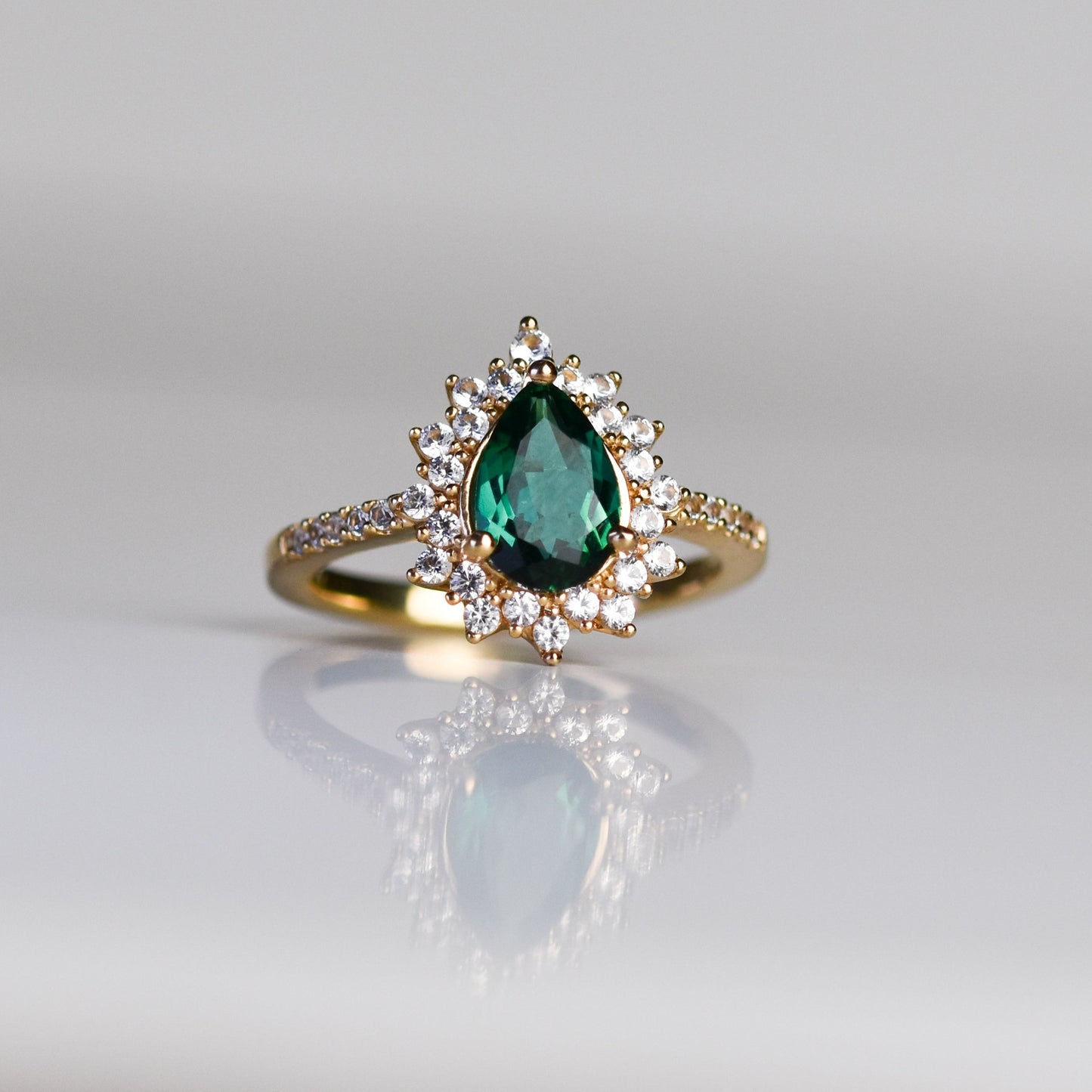 Anillo con Esmeralda en Gota y Halo de Zafiros Blancos