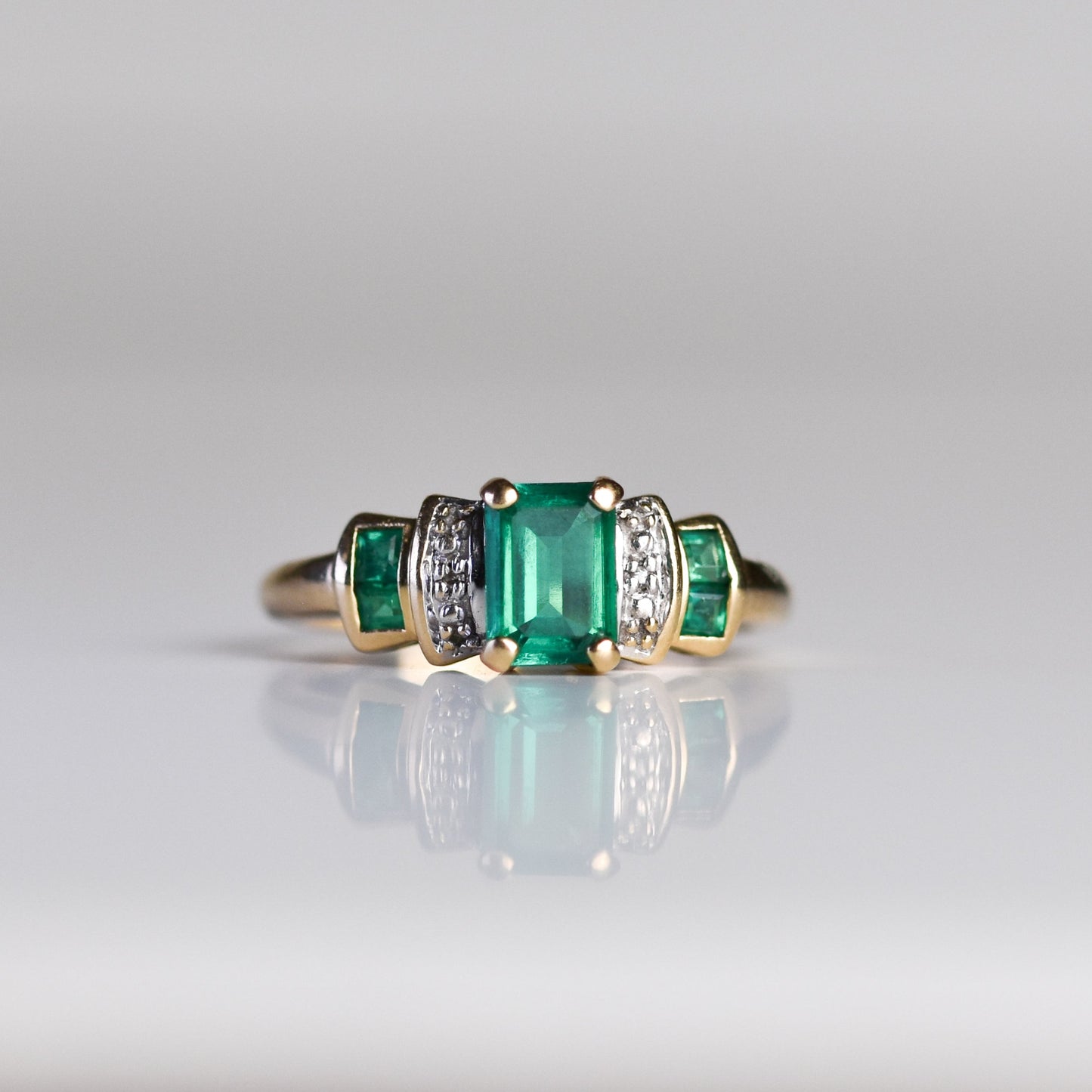 Anillo con esmeraldas de laboratorio y diamantes en oro amarillo 10K