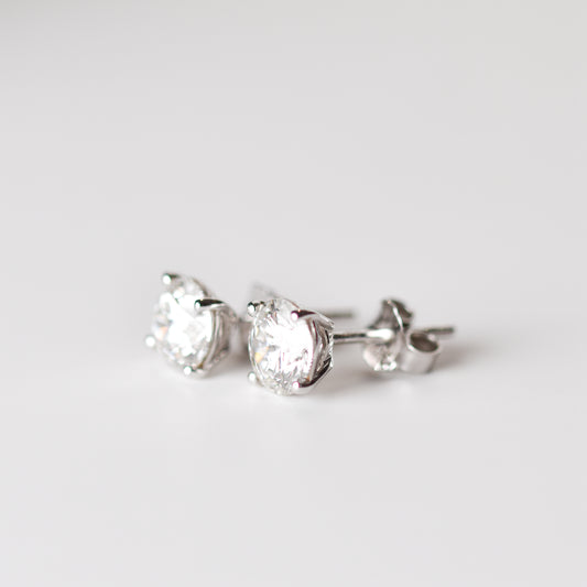 Aretes tipo stud con moissanitas en corte redondo y plata esterlina con baño de oro blanco 18K