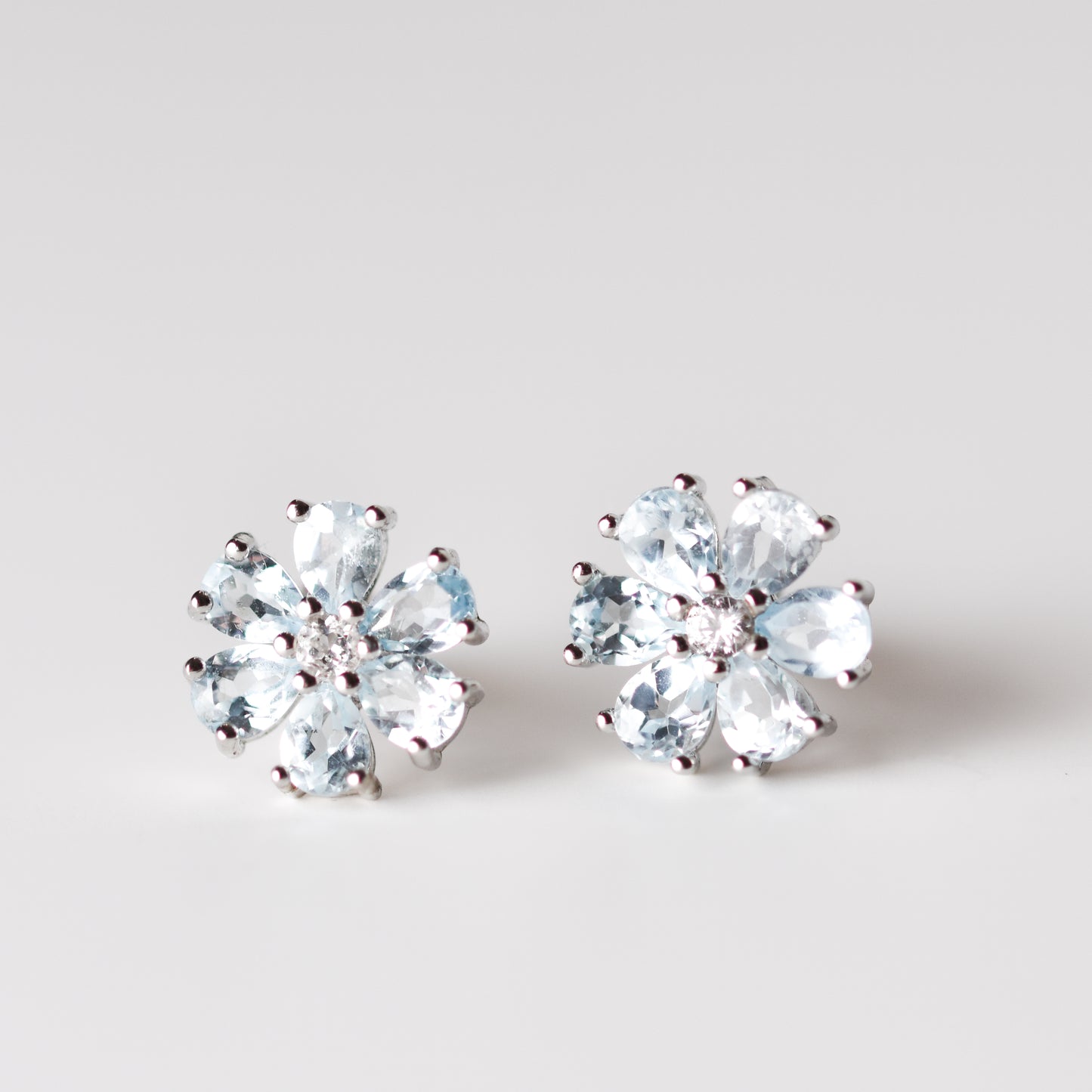 Aretes tipo flor con topacio azul natural y topacio blanco