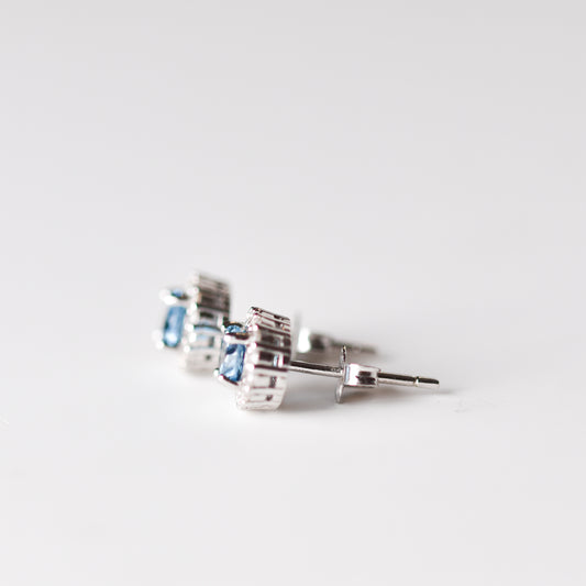 Aretes tipo stud con topacio London Blue y halo de zafiros blancos de laboratorio