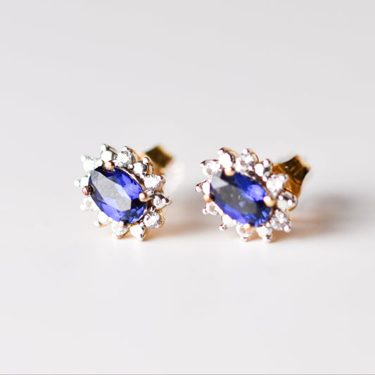 Aretes tipo stud con zafiro azul y zafiro blanco en plata con baño de oro