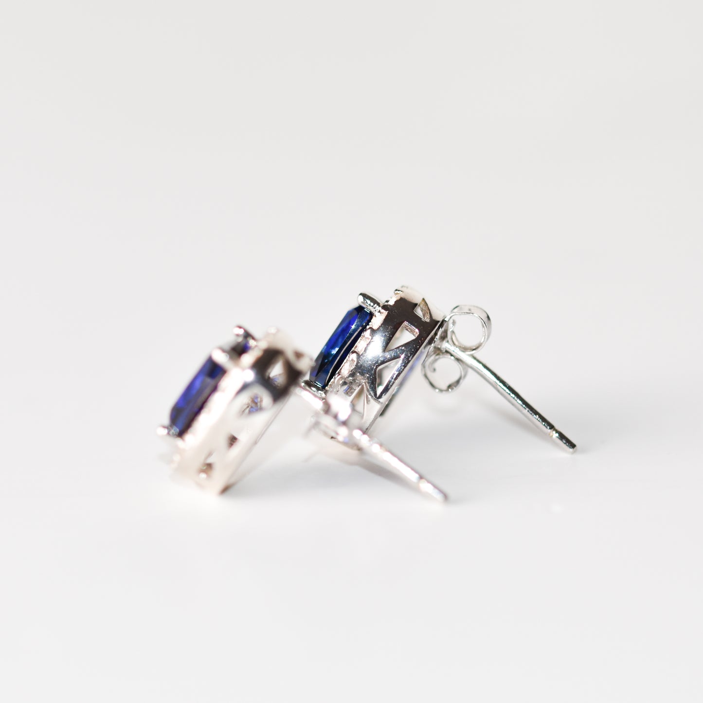 Aretes tipo stud con zafiro azul y halo de zafiros blancos creados en laboratorio
