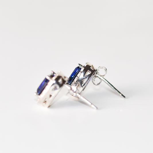 Aretes tipo stud con zafiro azul y halo de zafiros blancos creados en laboratorio