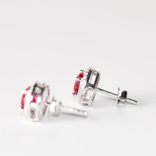 Aretes tipo stud con rubí (1.5 ct) y halo de zafiros blancos creados en laboratorio