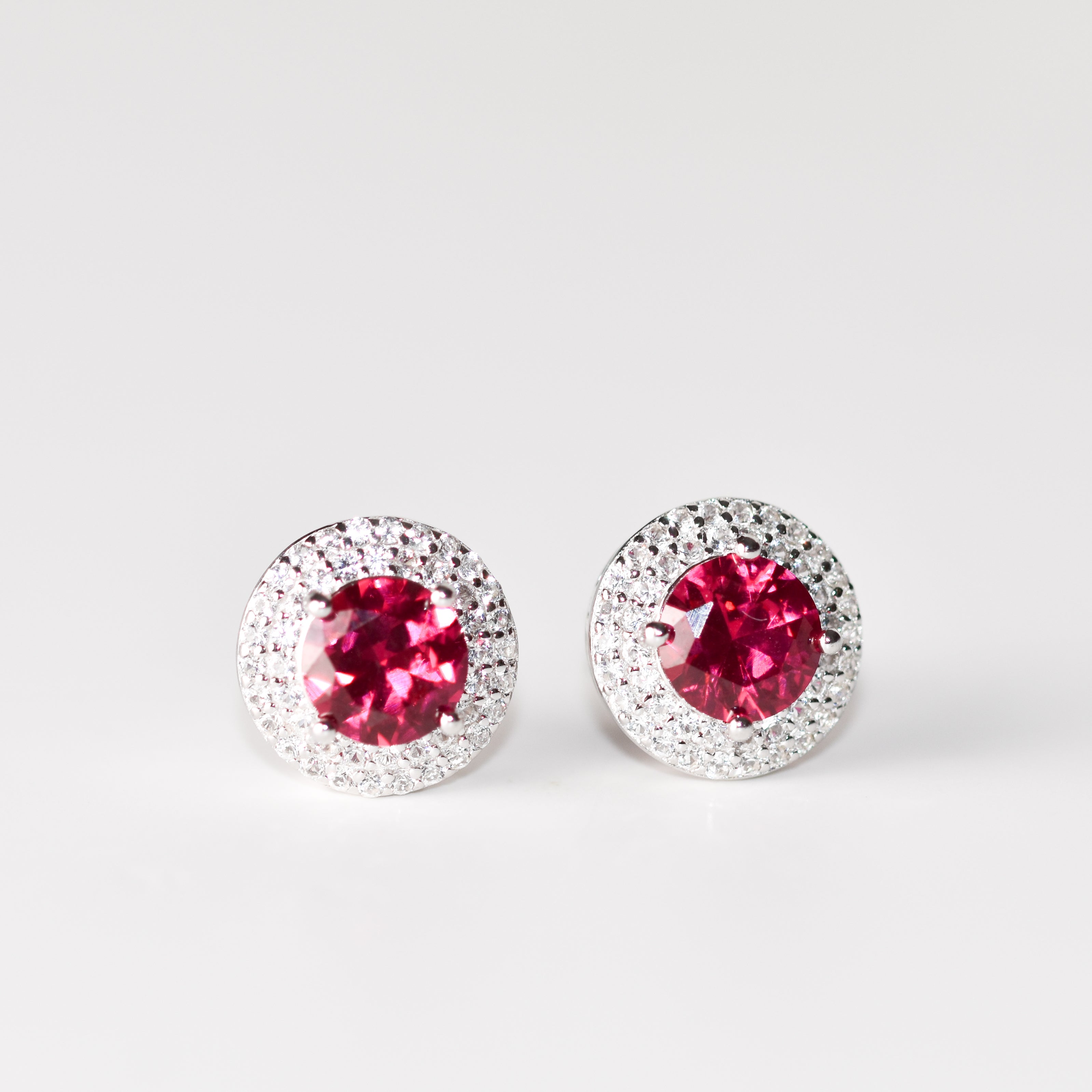 Aretes tipo stud redondos (1.5 ct) y halo de zafiros blancos