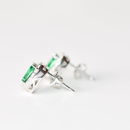 Aretes tipo stud con esmeralda y halo de zafiros blancos creados en laboratorio en plata esterlina