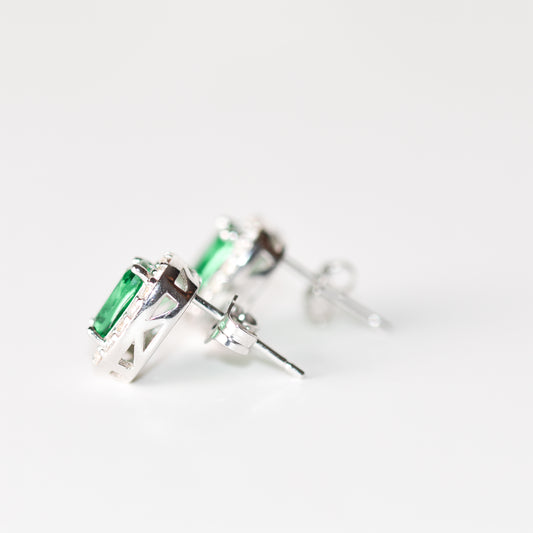 Aretes tipo stud con esmeralda y halo de zafiros blancos creados en laboratorio en plata esterlina