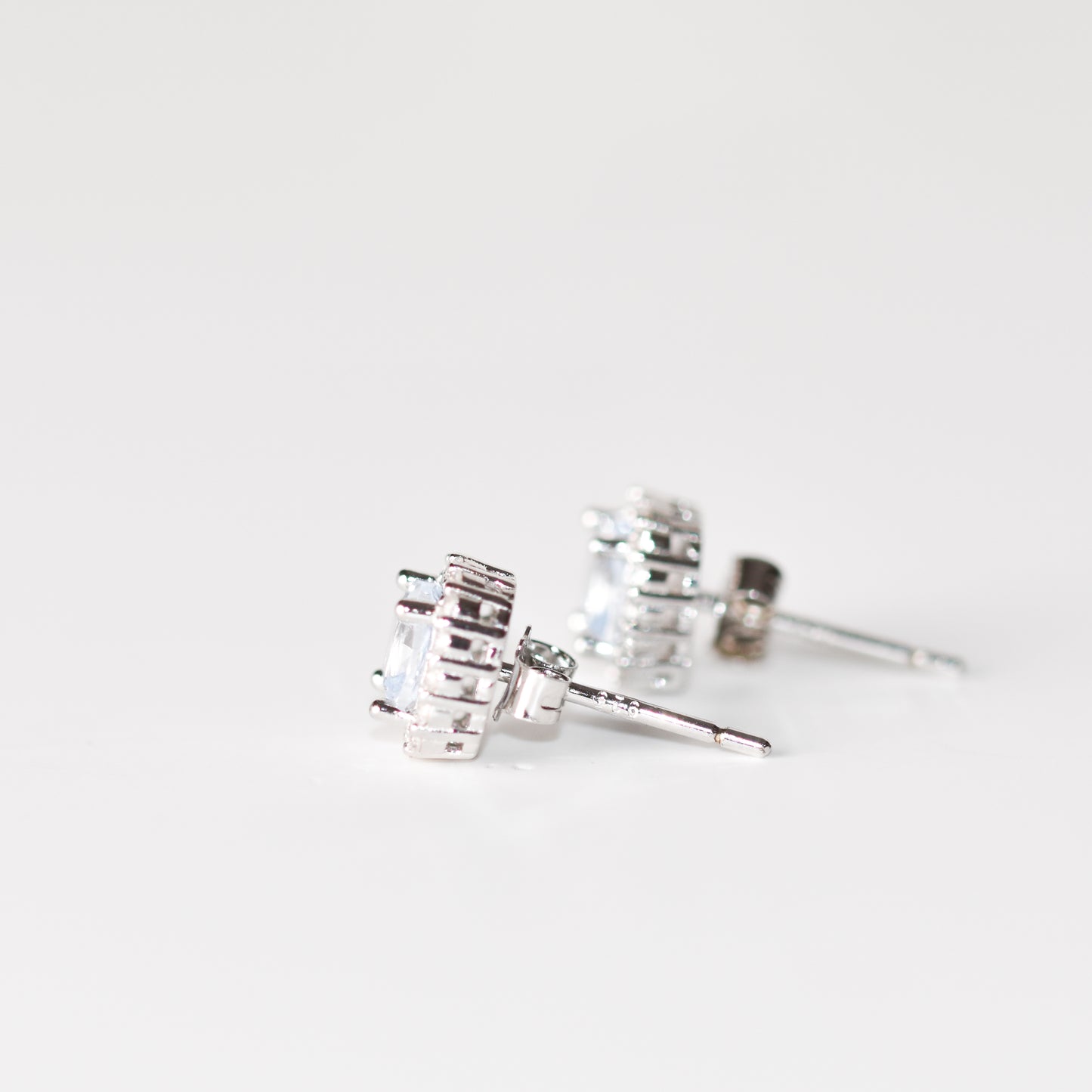 Aretes tipo stud con aguamarina y halo de zafiros blancos creados en laboratorio